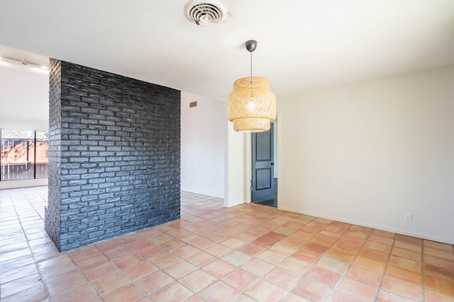 unfurnished room featuring light tile patterned floors, brick wall, and visible vents