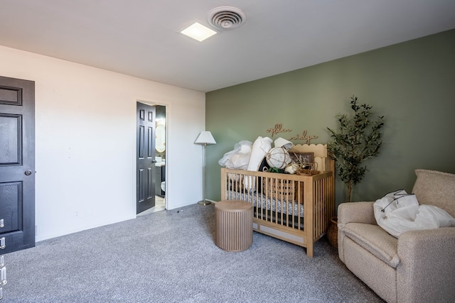 carpeted bedroom featuring a crib and visible vents