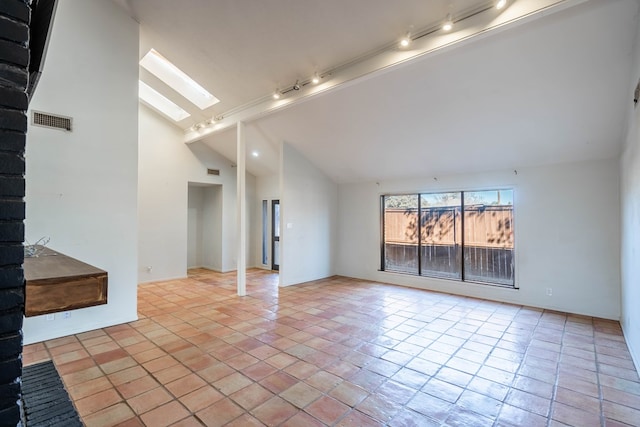 unfurnished room with a skylight, light tile patterned floors, visible vents, and high vaulted ceiling