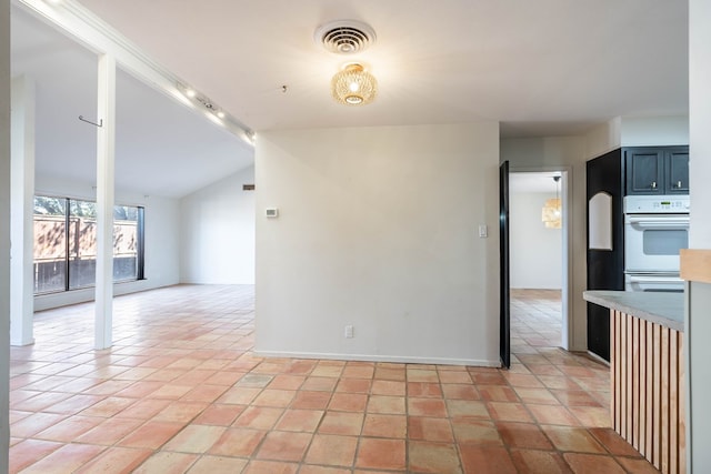 interior space with light tile patterned floors, lofted ceiling, light countertops, visible vents, and open floor plan