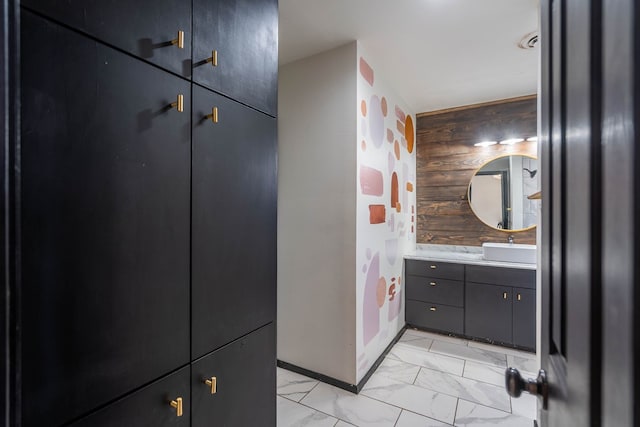 bathroom featuring marble finish floor, vanity, and baseboards