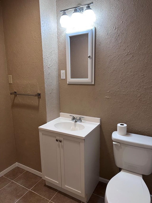 bathroom featuring tile patterned flooring, vanity, and toilet