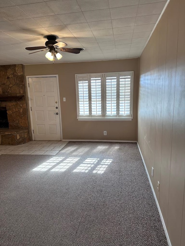 interior space featuring ceiling fan and a stone fireplace