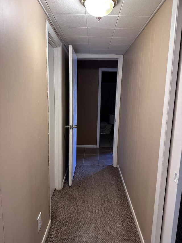 hall with dark carpet and wooden walls