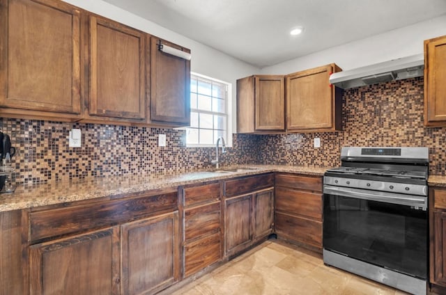 2401 Morrison Dr, Big Spring, TX 79720 - kitchen featuring light stone counters, a sink, backsplash, range hood, and stainless steel range with gas stovetop