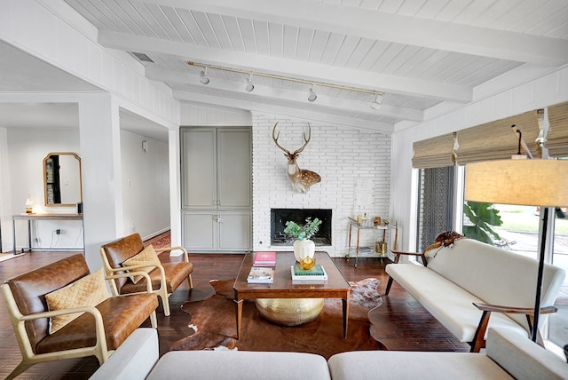 907 Harvard Ave, Midland, TX 79701 - living room featuring dark wood-style floors, a brick fireplace, wooden ceiling with exposed beams, and track lighting