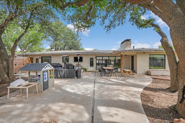 907 Harvard Ave, Midland, TX 79701 - back of house featuring brick siding, a patio, and a chimney