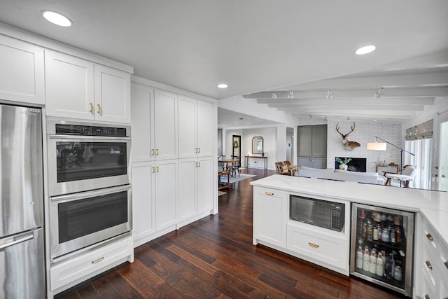 907 Harvard Ave, Midland, TX 79701 - kitchen featuring stainless steel appliances, beverage cooler, dark wood finished floors, open floor plan, and white cabinetry