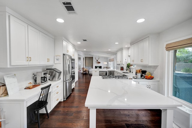 907 Harvard Ave, Midland, TX 79701 - kitchen with a peninsula, appliances with stainless steel finishes, recessed lighting, tasteful backsplash, and dark wood-type flooring