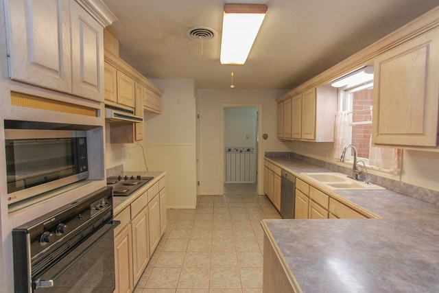 kitchen featuring sink, light tile patterned floors, stainless steel appliances, and light brown cabinetry