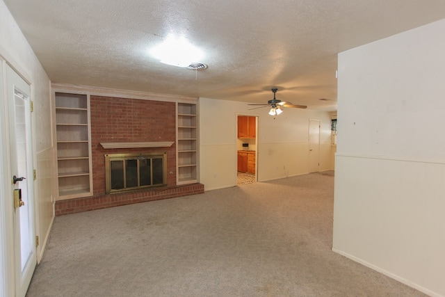 unfurnished living room with a textured ceiling, ceiling fan, light carpet, and a brick fireplace