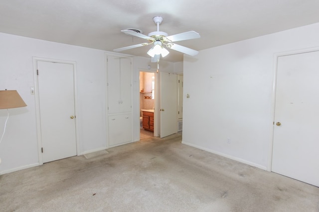 unfurnished bedroom with ceiling fan, light carpet, and connected bathroom