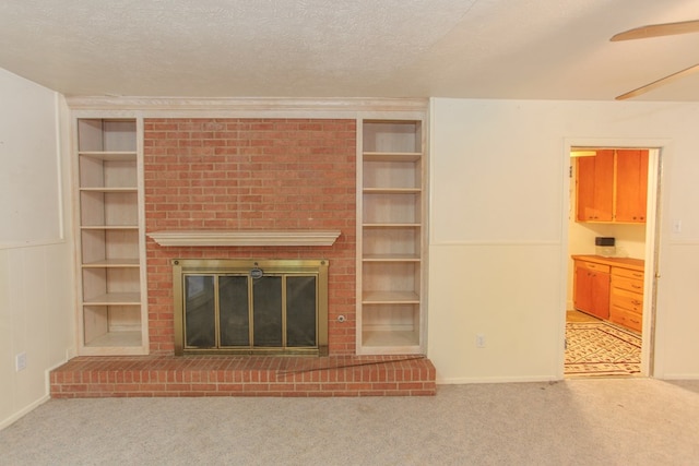 unfurnished living room featuring carpet flooring, a textured ceiling, a brick fireplace, and ceiling fan