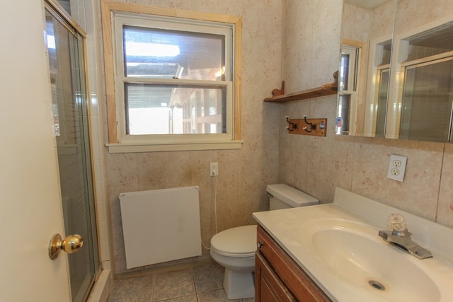 bathroom featuring toilet, tile patterned flooring, vanity, and walk in shower