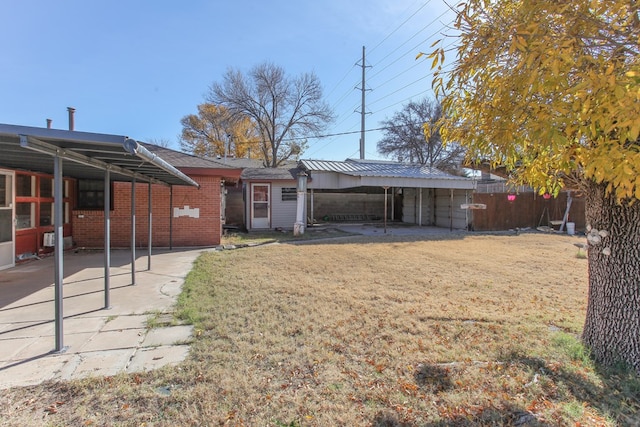 back of house featuring a lawn and an outbuilding