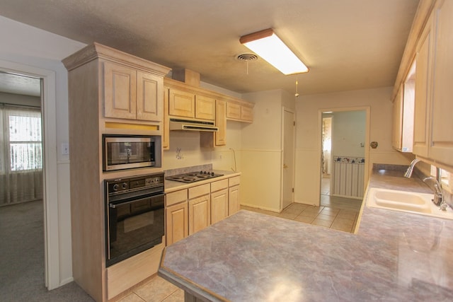 kitchen featuring sink, light tile patterned floors, stainless steel appliances, and light brown cabinetry