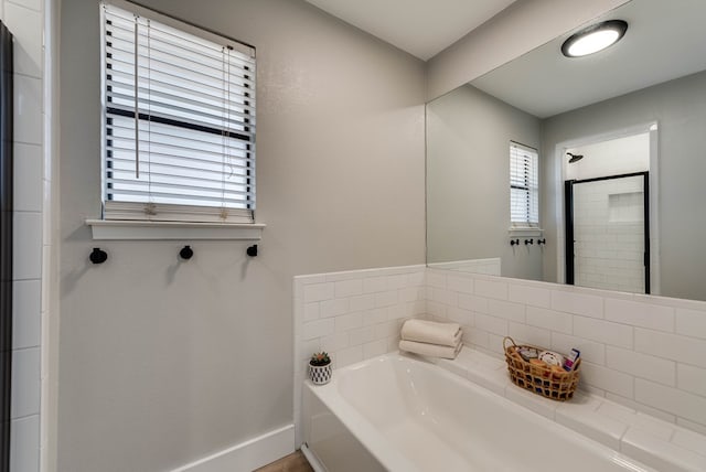full bathroom with baseboards, tiled shower, and a bath