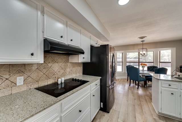 kitchen with under cabinet range hood, black electric cooktop, white cabinetry, and decorative backsplash