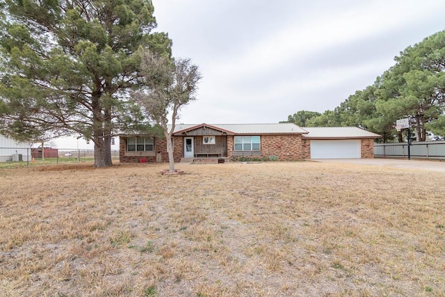 single story home featuring brick siding, an attached garage, and fence