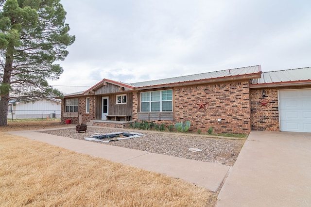 single story home featuring metal roof and brick siding