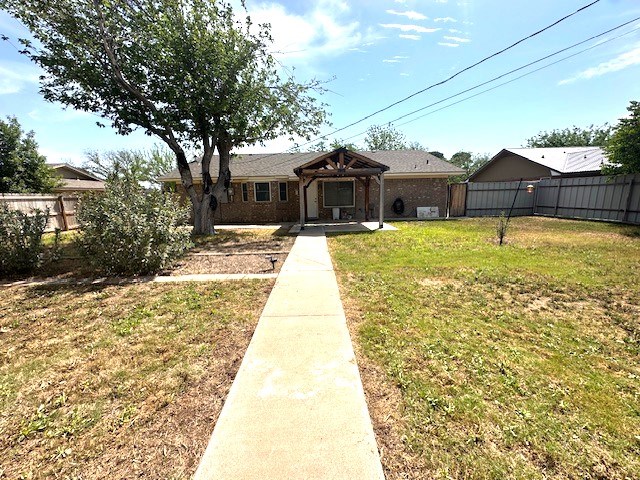 view of front of house with a gazebo, a fenced backyard, and a front lawn