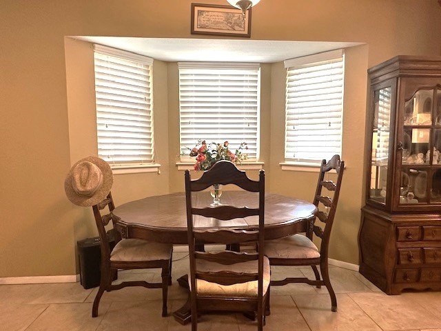 dining area featuring a wealth of natural light, baseboards, and light tile patterned floors