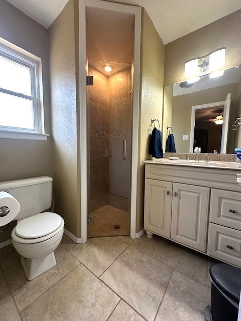 bathroom featuring baseboards, toilet, vanity, and a stall shower