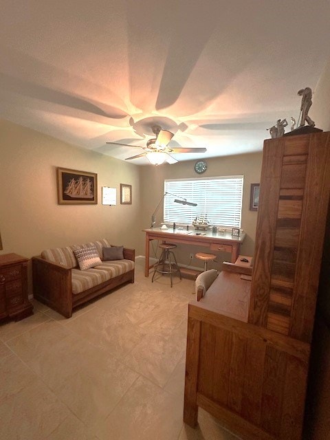 living area featuring ceiling fan and light tile patterned floors