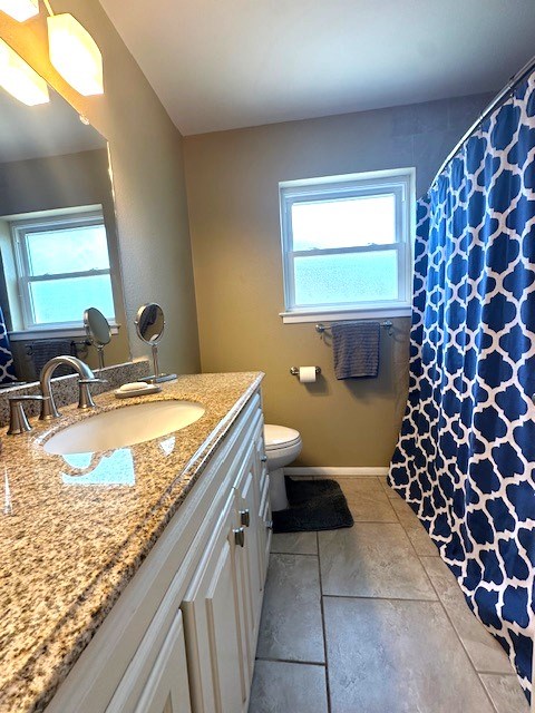 full bathroom with a shower with curtain, toilet, baseboards, tile patterned flooring, and vanity
