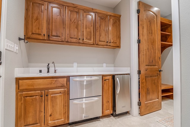 kitchen with light countertops, a sink, and brown cabinets