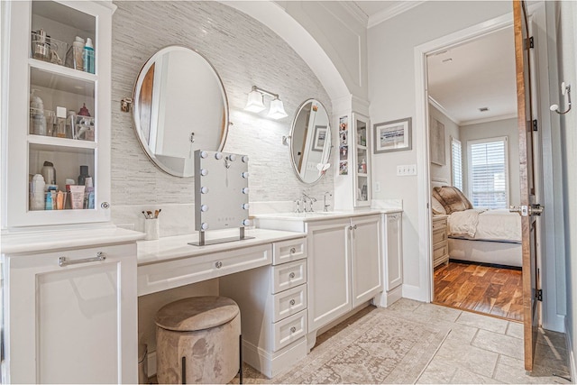 bathroom with stone tile floors, baseboards, connected bathroom, ornamental molding, and vanity