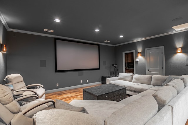 cinema with recessed lighting, wood finished floors, visible vents, baseboards, and ornamental molding