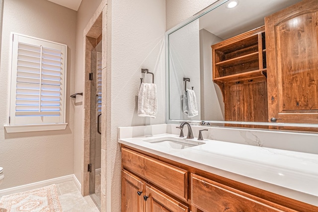 bathroom with a stall shower, baseboards, a textured wall, toilet, and vanity