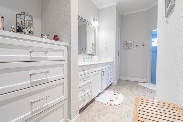 full bathroom featuring a textured wall, ornamental molding, vanity, and baseboards