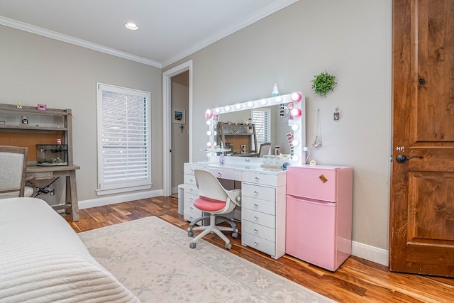 bedroom with ornamental molding, freestanding refrigerator, wood finished floors, multiple windows, and baseboards