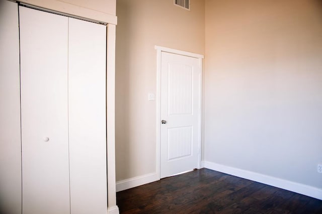 unfurnished bedroom with dark hardwood / wood-style flooring