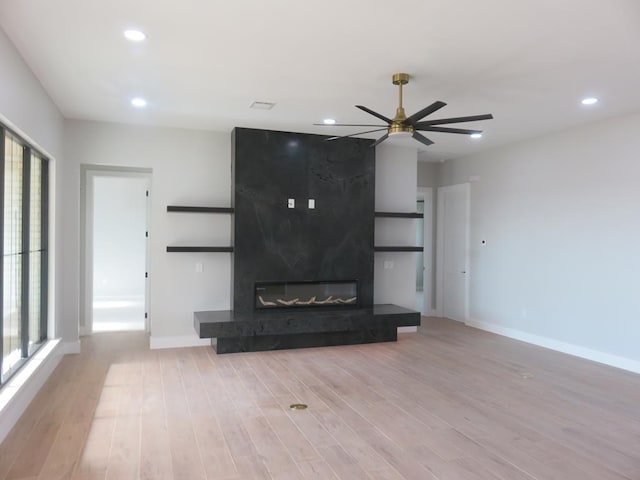 9811 E County Rd 108, Midland, TX 79706 - unfurnished living room featuring wood finished floors, ceiling fan, recessed lighting, and a premium fireplace