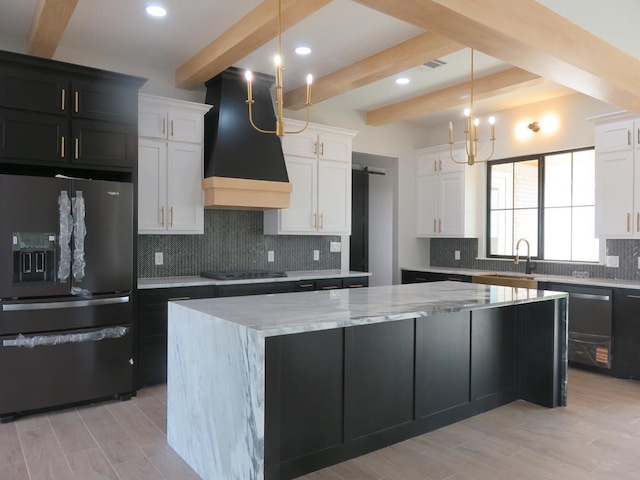 9811 E County Rd 108, Midland, TX 79706 - kitchen with refrigerator with ice dispenser, exhaust hood, beamed ceiling, black electric stovetop, and a center island