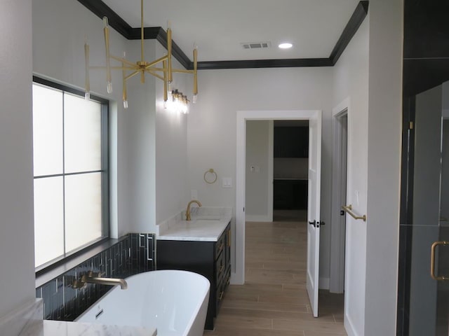 9811 E County Rd 108, Midland, TX 79706 - bathroom featuring a freestanding tub, wood finished floors, ceiling fan, ornamental molding, and vanity