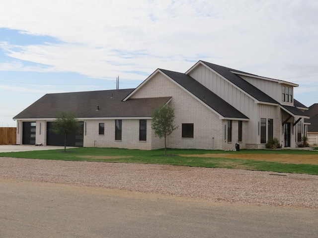 9811 E County Rd 108, Midland, TX 79706 - view of front of house with board and batten siding, concrete driveway, a garage, and a front lawn