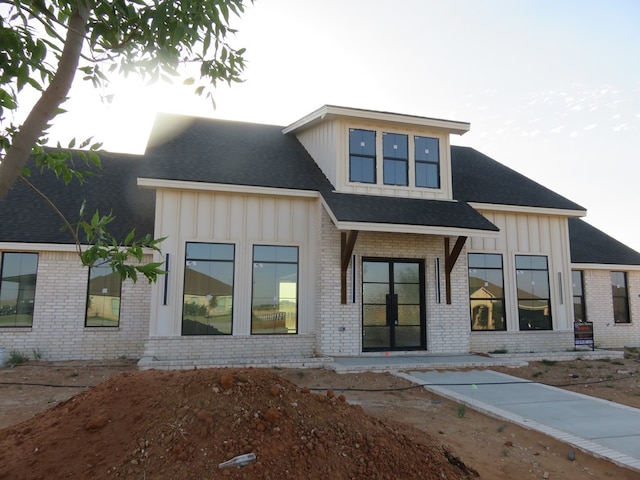 9811 E County Rd 108, Midland, TX 79706 - view of front facade featuring board and batten siding, brick siding, and roof with shingles