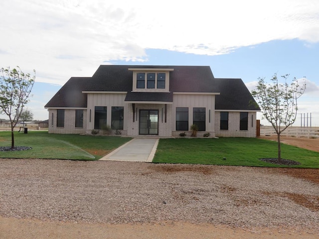 9811 E County Rd 108, Midland, TX 79706 - view of front of house with a front lawn, brick siding, and board and batten siding
