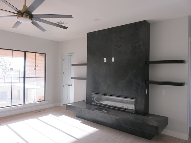 9811 E County Rd 108, Midland, TX 79706 - unfurnished living room with ceiling fan, a premium fireplace, baseboards, and wood finished floors
