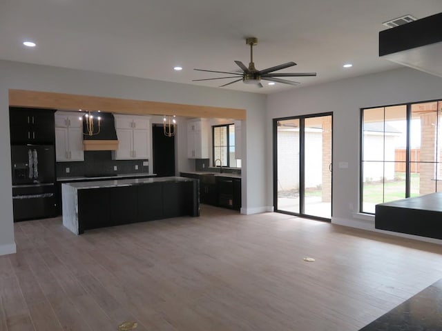 9811 E County Rd 108, Midland, TX 79706 - kitchen with ventilation hood, a kitchen island, light wood-style floors, open floor plan, and recessed lighting