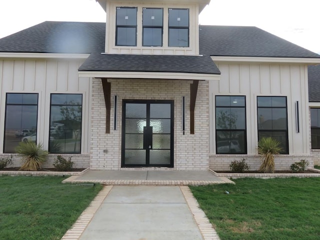 9811 E County Rd 108, Midland, TX 79706 - doorway to property with board and batten siding, a shingled roof, and brick siding