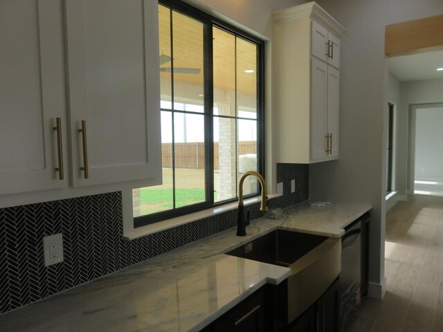 9811 E County Rd 108, Midland, TX 79706 - kitchen with tasteful backsplash, light stone counters, white cabinetry, and dishwashing machine