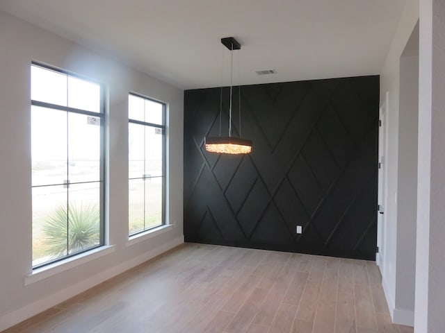 9811 E County Rd 108, Midland, TX 79706 - unfurnished dining area featuring light wood-style floors and an accent wall