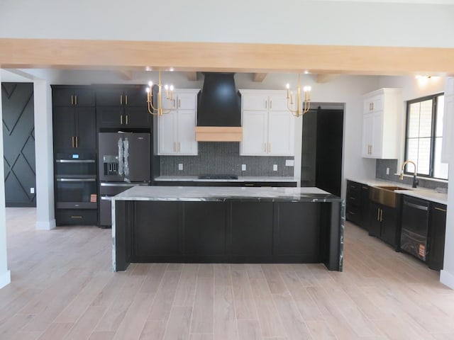 9811 E County Rd 108, Midland, TX 79706 - kitchen with stainless steel fridge, a chandelier, custom exhaust hood, black electric cooktop, and dishwashing machine