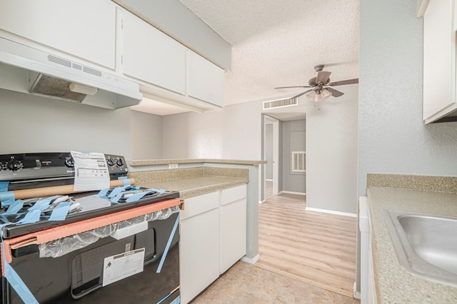 kitchen featuring sink, ceiling fan, black range with electric stovetop, a textured ceiling, and white cabinets