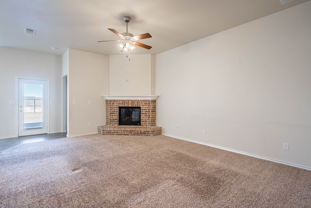 unfurnished living room with a brick fireplace, ceiling fan, and carpet